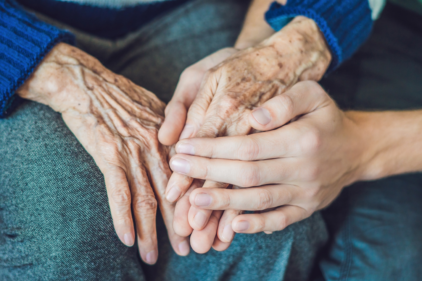 Zwei Menschen halten Hände. In der Palliativversorgung steht Nähe und Zuwendung im Vordergrund
