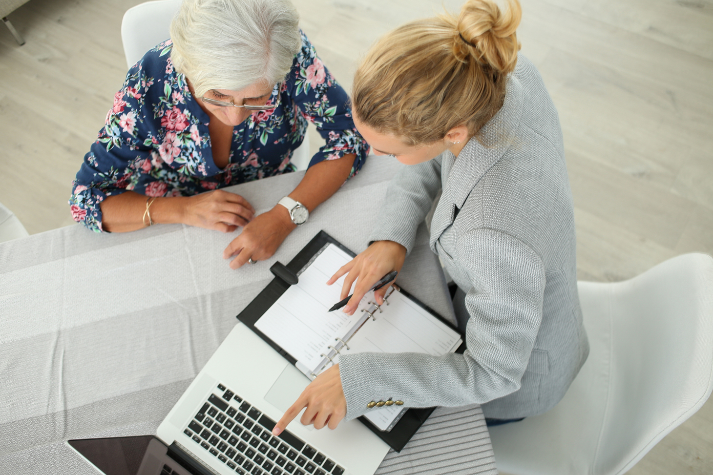 Eine Seniorin lässt sich von einer Frau zum Thema Sterbegeldversicherung beraten.